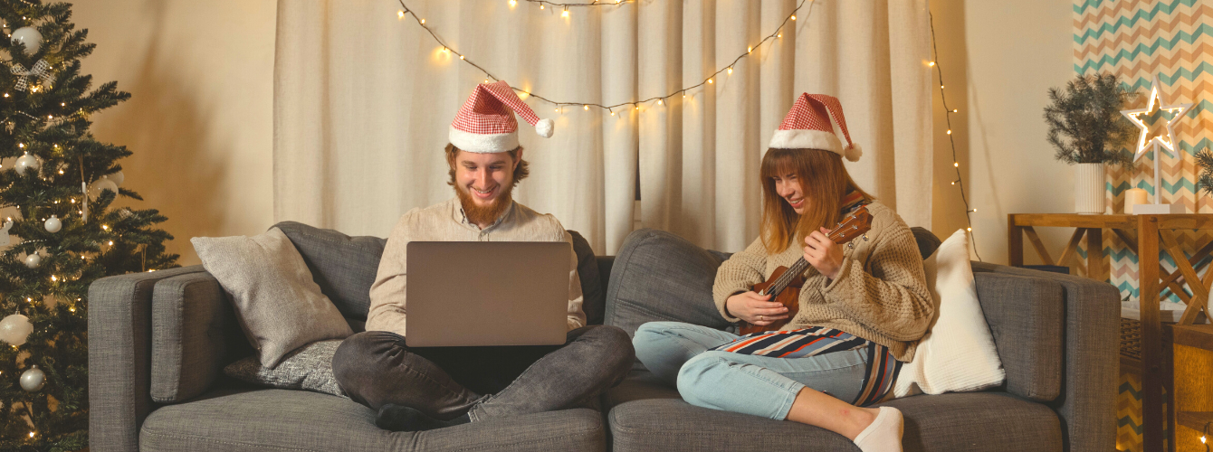 Boy and girl on the sofa wearing Christmas hats